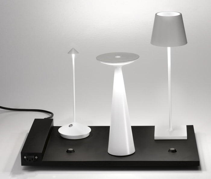 A modern black cordless desk lamp with a unique flat base, including a modular charging system and spherical bulbs on a white background from Zafferano's 6-Lamp Charging Carpet.