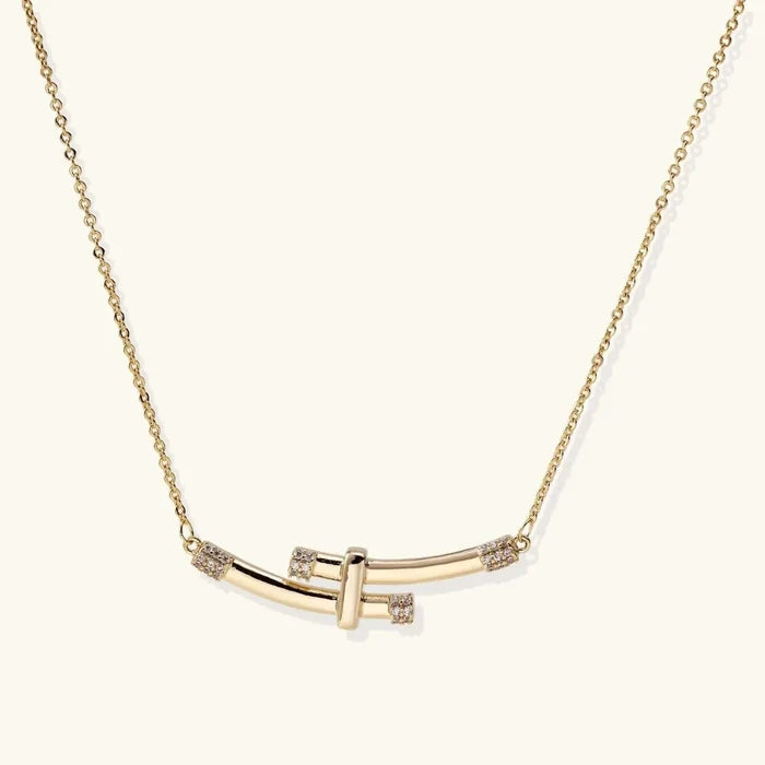 Bamboo Arc Necklace with a fine gold-tone chain and crossed polished curved bars accented by clear stones