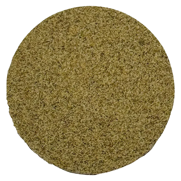 Top-down view of a dense, light-brown puck of Dry Sift Press Hash filling the circular frame.