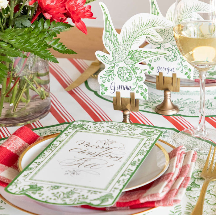 An elegant table setting featuring the Green Asiatic Pheasants Place Card with "Gemma" written on it, paired with the Green Regal Peacock Placemat and  table card.
