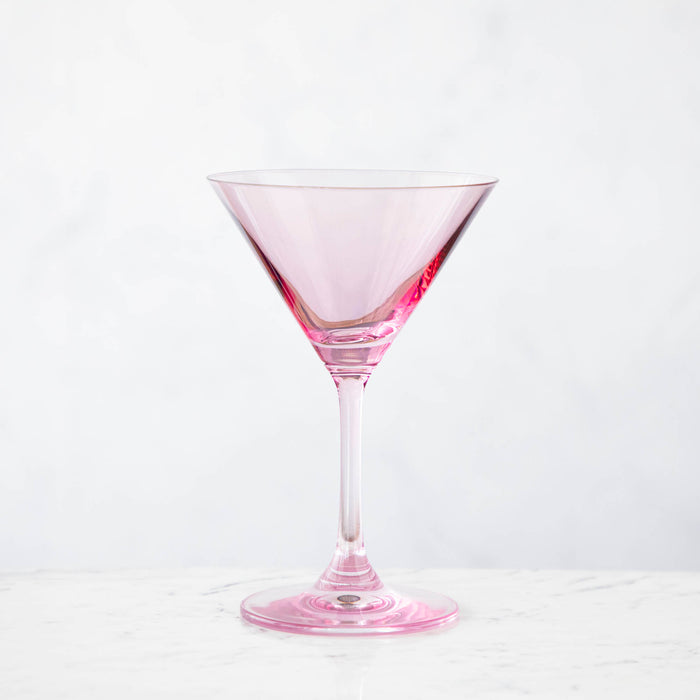 A pink crystal stemware wine glass on a marble table.