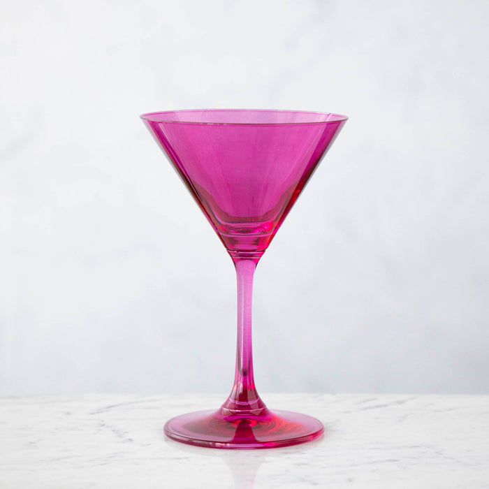 A pink crystal stemware wine glass on a marble table.