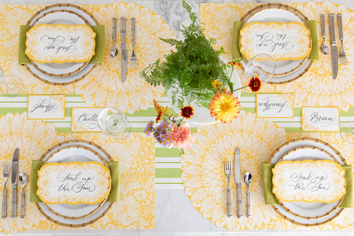 A vibrant table setting for four featuring Spring Blooms Table Cards resting on each plate, from above.